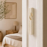 Close-up of Jerusalem stone mezuzah mounted on a residential doorpost in a natural entryway scene.
