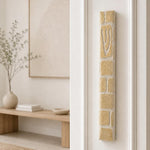 Plain cream Jerusalem stone mezuzah mounted on the right doorpost of an entryway.