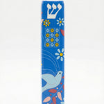 Ceramic Dove of Peace mezuzah with Hebrew letters and decorative motifs, set against a white background with soft reflection.