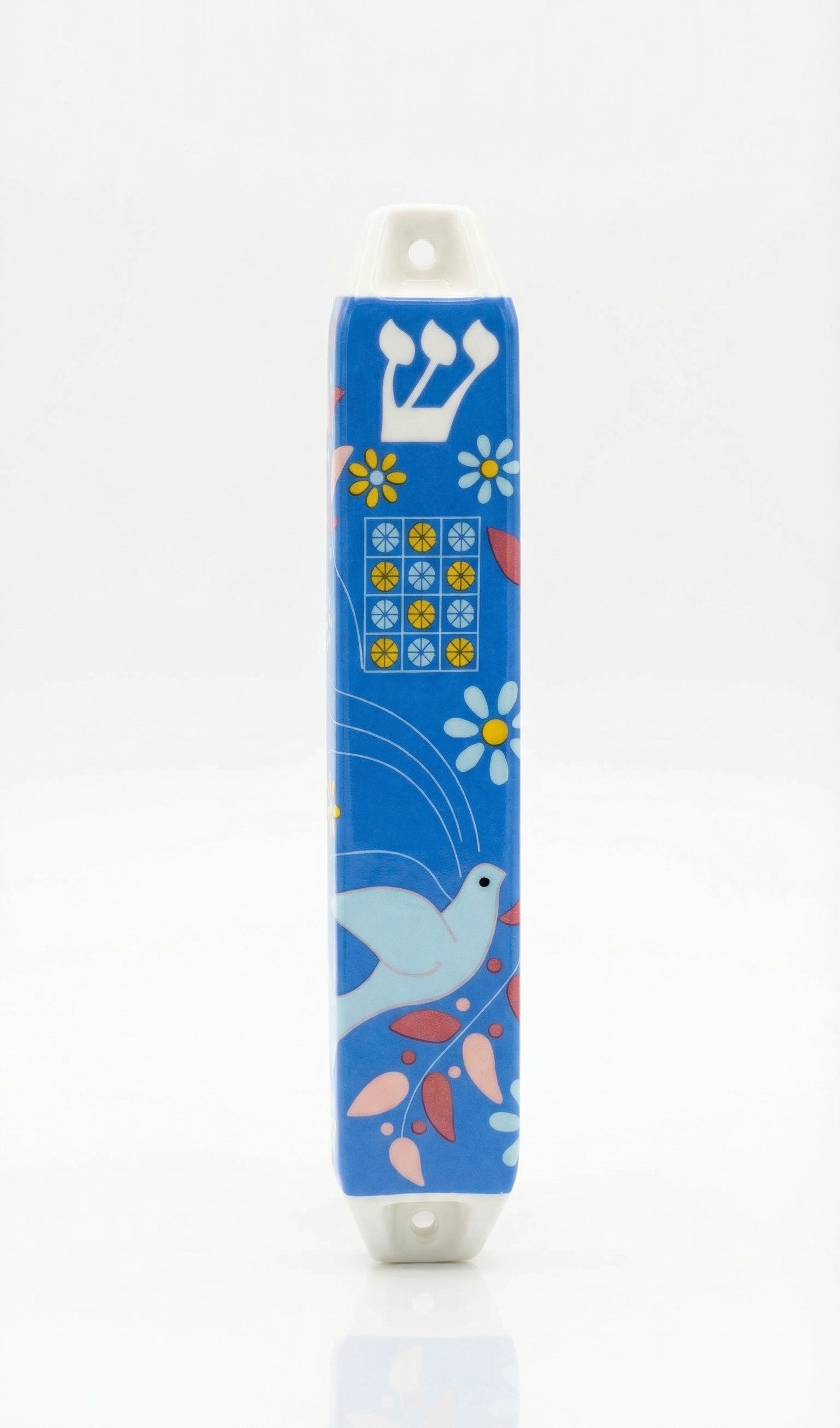 Ceramic Dove of Peace mezuzah with Hebrew letters and decorative motifs, set against a white background with soft reflection.