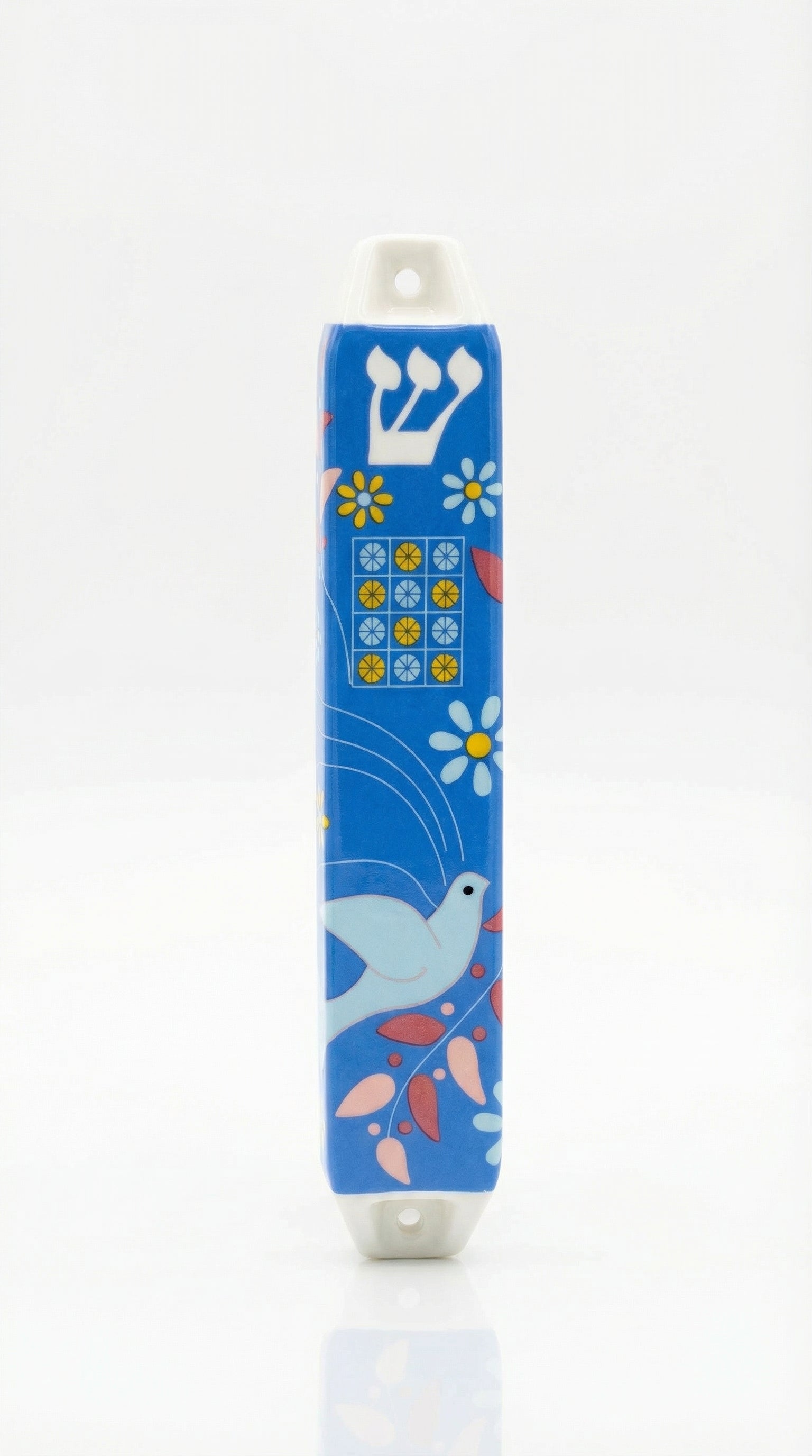 Ceramic Dove of Peace mezuzah with Hebrew letters and decorative motifs, set against a white background with soft reflection.