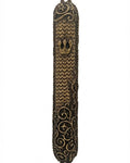 Elegant brass Mezuzah with intricate carvings and Hebrew inscriptions, displayed on a pure white background with subtle reflection.