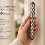 Person holding an elegant crowned spiral stainless steel mezuzah case with detailed beaded accents and a center Shin symbol.