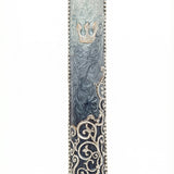 Elegant pewter mezuzah hand painted with enamel, measuring 5 inches tall, with intricate swirl details and Hebrew inscription, on a white studio background with soft reflection.