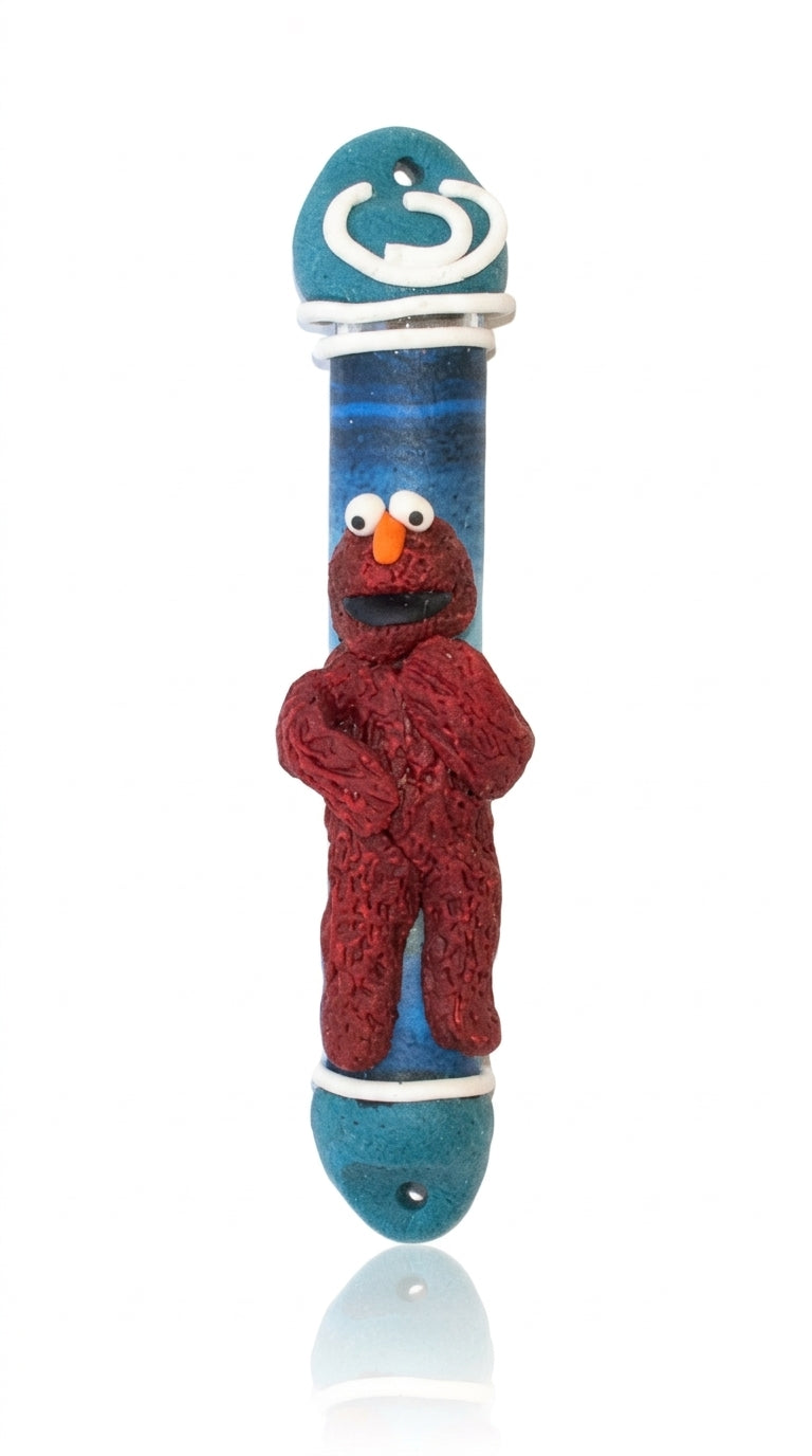 Elmo plush toy Mezuzah for children's room decoration, made in Israel, 4 inches tall with Hebrew inscription, on a white background.