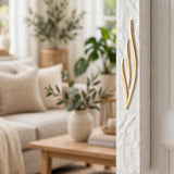 Extra Large Golden Esh White Concrete Mezuzah mounted on a white doorpost beside a sunlit living room, its hand-textured white surface and tall flame-shaped gold Shin showing the scale of this waterproof 8-inch scroll mezuzah case