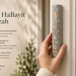 Person holding an extra large textured gray concrete mezuzah with gold Hebrew lettering and Birkat HaBayit prayer.