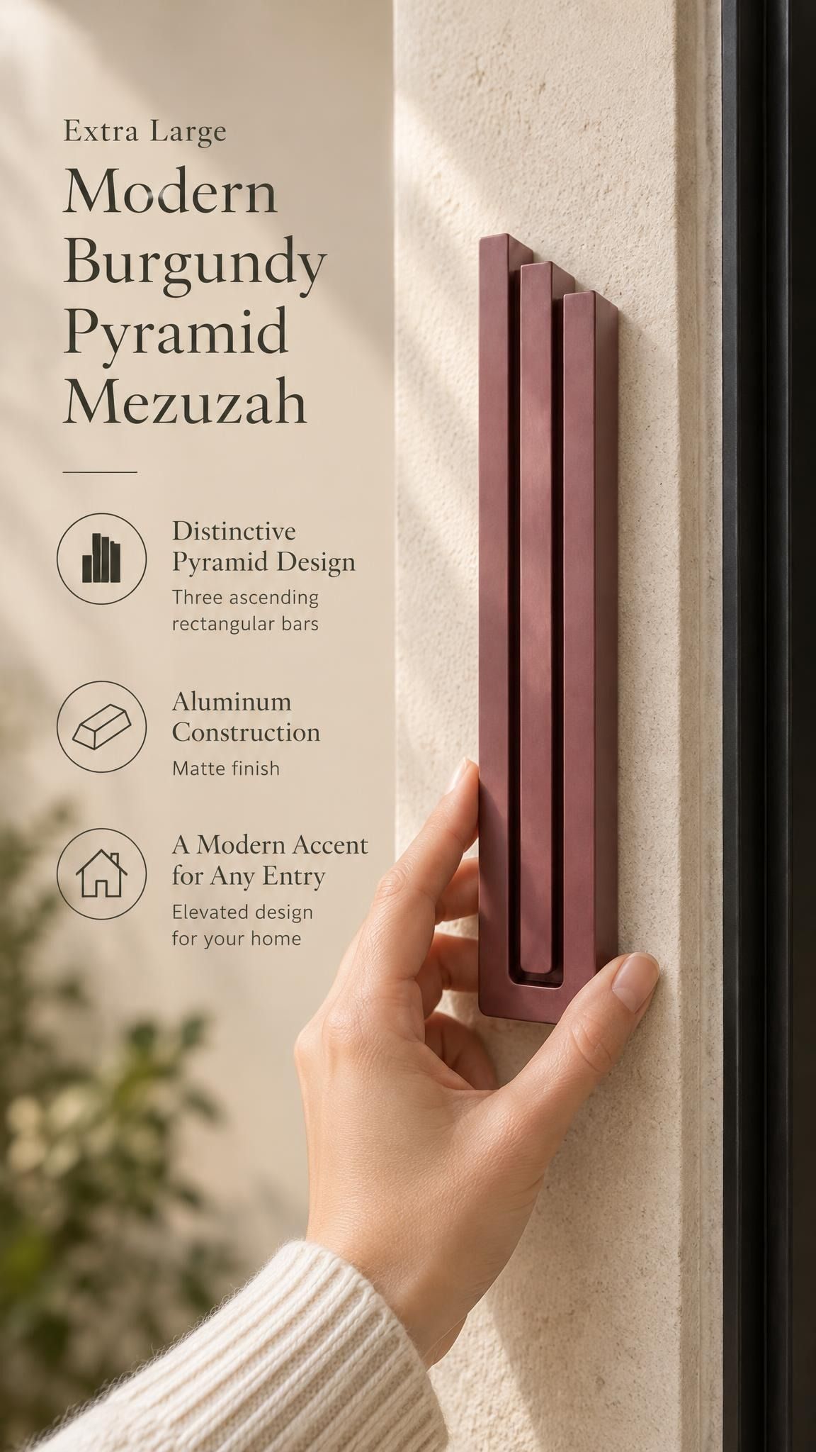 Extra Large Modern Burgundy Pyramid Mezuzah held beside a doorpost, with the muted burgundy wine-red aluminum mezuzah cover shown close enough to reveal its three stepped bars and rounded lower edge alongside product-name and design callouts for this minimalist Judaica piece