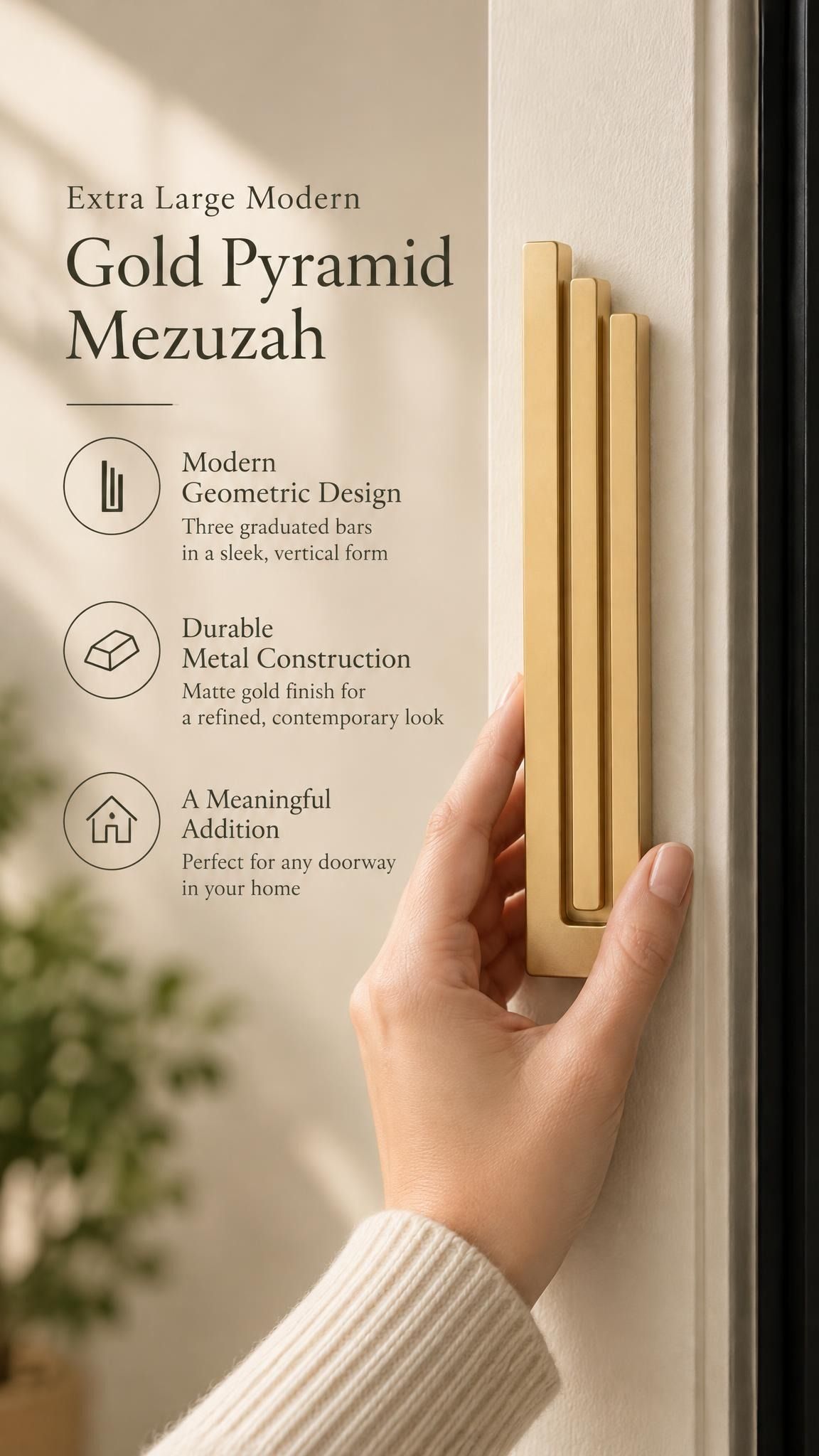 Extra Large Modern Gold Pyramid Mezuzah held beside a doorpost, with the warm metallic gold aluminum mezuzah cover shown close enough to reveal its three stepped bars and rounded lower edge alongside product-name and design callouts for this minimalist Judaica piece