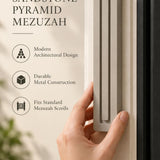 Extra Large Modern Sandstone Pyramid Mezuzah held beside a doorpost, with the warm taupe sandstone aluminum mezuzah cover shown close enough to reveal its three stepped bars and rounded lower edge alongside product-name and design callouts for this minimalist Judaica piece
