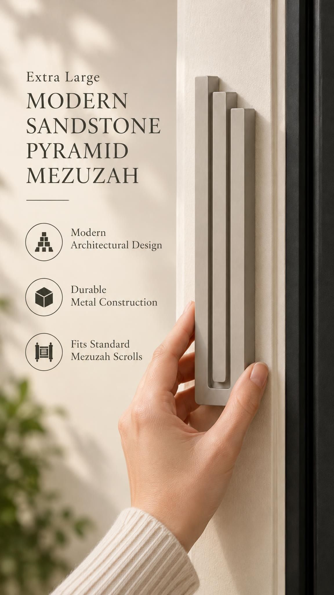 Extra Large Modern Sandstone Pyramid Mezuzah held beside a doorpost, with the warm taupe sandstone aluminum mezuzah cover shown close enough to reveal its three stepped bars and rounded lower edge alongside product-name and design callouts for this minimalist Judaica piece