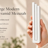 Extra Large Modern White Pyramid Mezuzah pictured in hand as a smooth matte white aluminum mezuzah cover with three graduated bars and a contemporary stepped design, alongside its name and illustrated product features in a wide social-sharing image