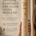 Hand-held view of the extra-large Shaddai Ramparts Jerusalem Stone Mezuzah showing its height, texture, Hebrew engravings, and gold lettering.