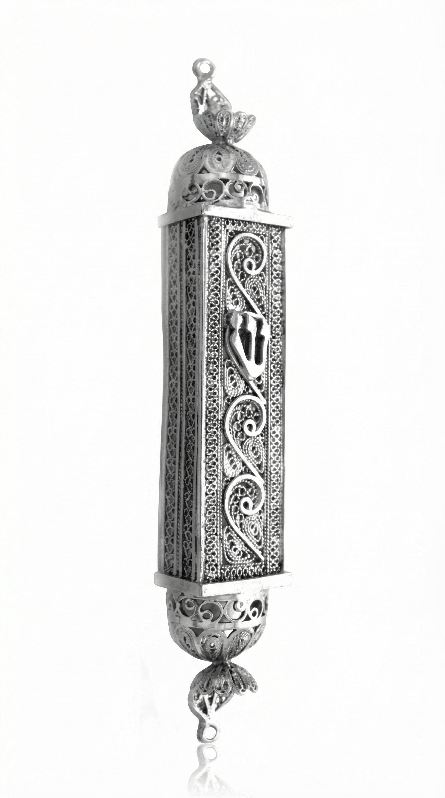 Handcrafted sterling silver mezuzah with intricate filigree and engraved Hebrew symbols, on a pure white background with soft reflection.