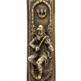 Brass finish Fiddler on the Roof Mezuzah with detailed engravings, Hebrew letters, and decorative motifs, shown on a white studio surface with subtle reflection.