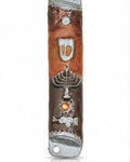 Passionate pewter mezuzah with enamel featuring a menorah and Hebrew letter Shin, displayed on a white studio background with soft reflection.