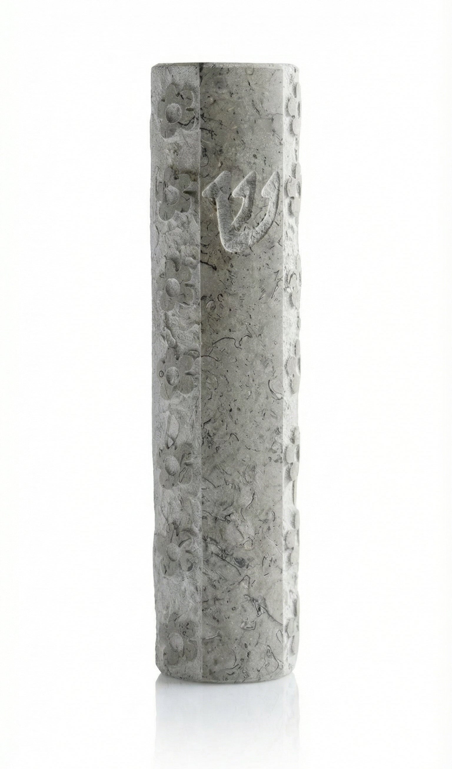 Handcrafted Jerusalem stone mezuzah with Hebrew inscriptions, detailed surface texture, and decorative motifs on a white background with soft reflection.