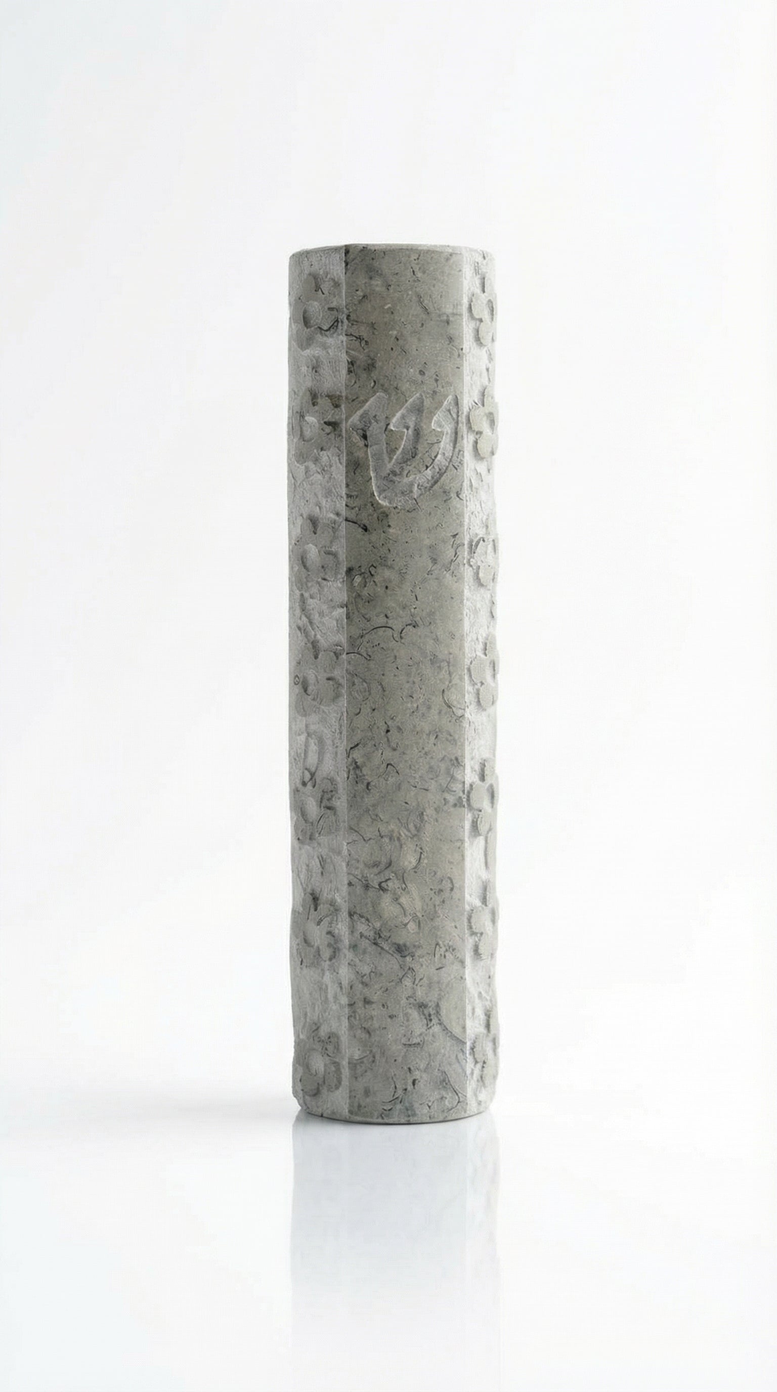Handcrafted Jerusalem stone mezuzah with floral motifs, Hebrew script, and decorative details, on a white studio background with subtle reflection.