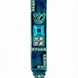 Ornate pewter Gems Mezuzah with blue enamel and decorative stones on a white background with soft reflection.