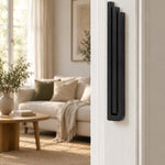 Giant Modern Black Pyramid Mezuzah mounted vertically on a white interior doorpost, where its deep matte black aluminum mezuzah cover and three graduated bars create a architectural Judaica accent with clean geometric lines against the pale doorframe