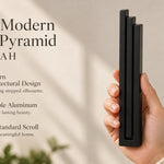 Giant Modern Black Pyramid Mezuzah pictured in hand as a deep matte black aluminum mezuzah cover with three graduated bars and a architectural stepped design, alongside its name and illustrated product features in a wide social-sharing image