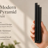 Giant Modern Black Pyramid Mezuzah pictured in hand as a deep matte black aluminum mezuzah cover with three graduated bars and a architectural stepped design, alongside its name and illustrated product features in a wide social-sharing image