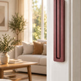 Giant Modern Burgundy Pyramid Mezuzah mounted vertically on a white interior doorpost, where its muted burgundy wine-red aluminum mezuzah cover and three graduated bars create a architectural Judaica accent with clean geometric lines against the pale doorframe