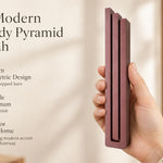 Giant Modern Burgundy Pyramid Mezuzah pictured in hand as a muted burgundy wine-red aluminum mezuzah cover with three graduated bars and a architectural stepped design, alongside its name and illustrated product features in a wide social-sharing image