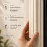 Giant Modern Cream Pyramid Mezuzah held beside a doorpost, with the warm ivory cream aluminum mezuzah cover shown close enough to reveal its three stepped bars and rounded lower edge alongside product-name and design callouts for this contemporary Judaica piece