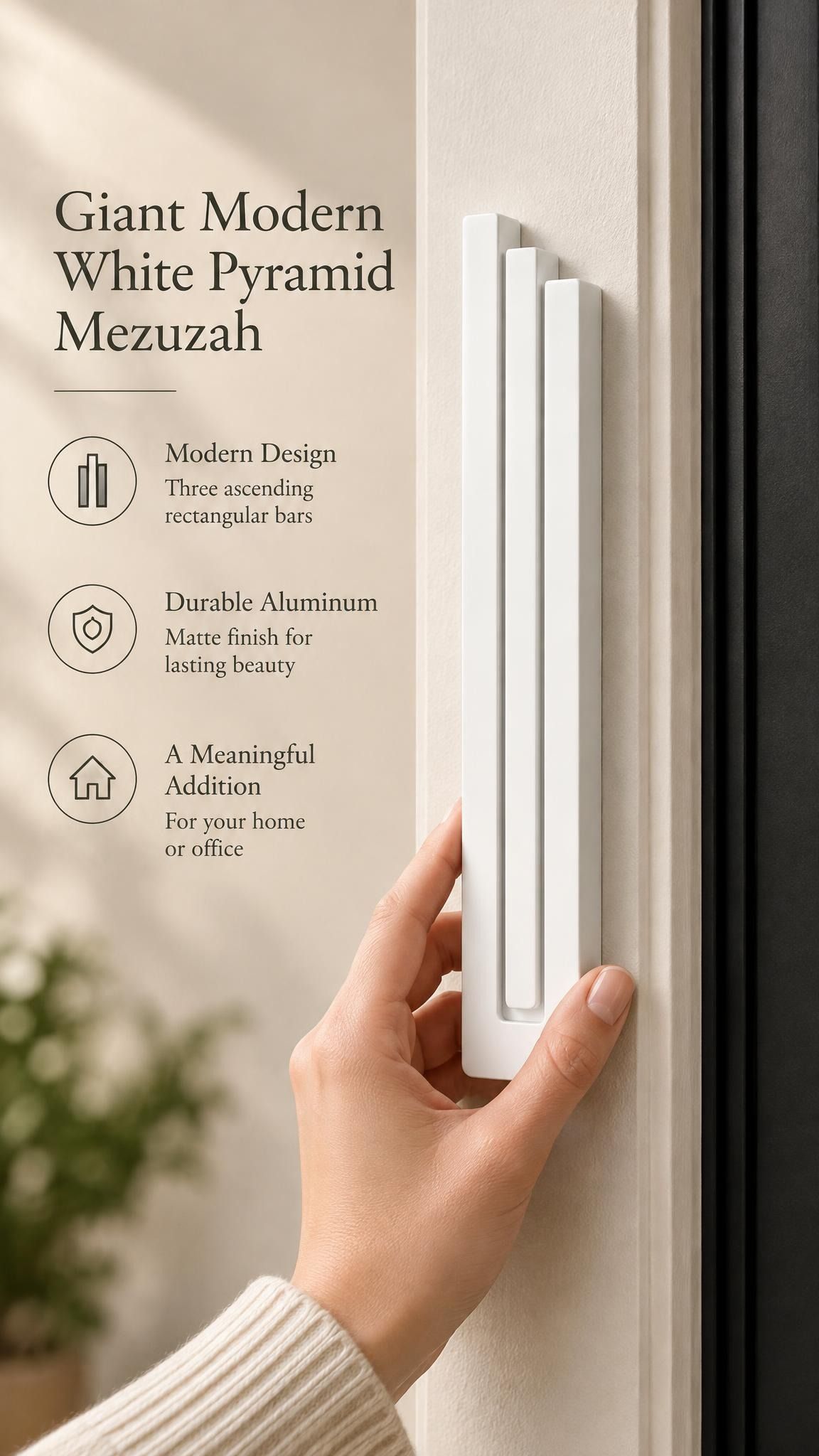 Giant Modern White Pyramid Mezuzah held beside a doorpost, with the smooth matte white aluminum mezuzah cover shown close enough to reveal its three stepped bars and rounded lower edge alongside product-name and design callouts for this architectural Judaica piece