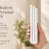 Giant Modern White Pyramid Mezuzah pictured in hand as a smooth matte white aluminum mezuzah cover with three graduated bars and a architectural stepped design, alongside its name and illustrated product features in a wide social-sharing image