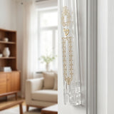 Elegant clear lucite mezuzah case with gold detailing on interior doorway wall, complementing modern interior design.