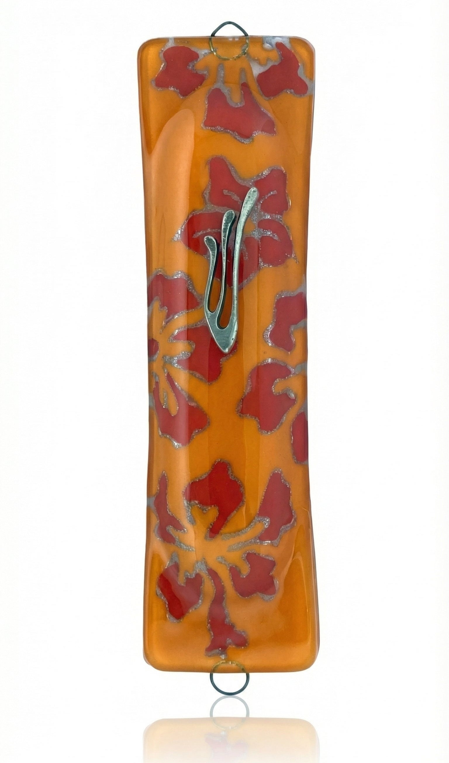 Glass art Mezuzah in vibrant orange color with detailed engraved Hebrew lettering, displayed against a white studio background with subtle reflection.