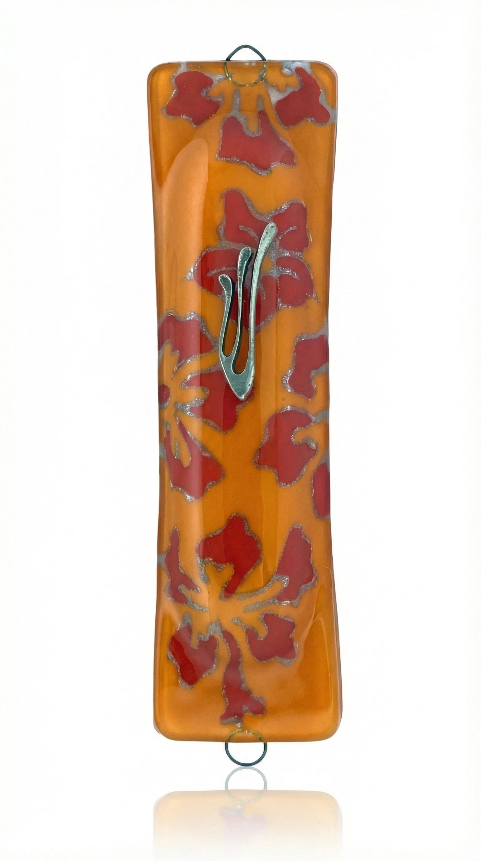 Glass art Mezuzah in vibrant orange color with detailed engraved Hebrew lettering, displayed against a white studio background with subtle reflection.