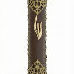 Upscale gold and leather mezuzah made in Israel with detailed engravings and Hebrew letters, displayed on a pure white studio background with soft reflection.