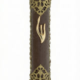 Upscale gold and leather mezuzah made in Israel with detailed engravings and Hebrew letters, displayed on a pure white studio background with soft reflection.