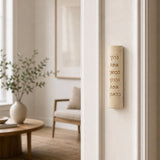 Golden Blessings Jerusalem stone mezuzah mounted vertically on a residential doorpost entrance.