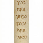 Handcrafted Jerusalem stone mezuzah with Hebrew blessings, natural color variations, and intricate engraved details, mounted on a white background.