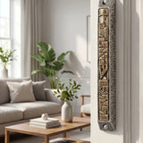 Elegant Golden Cityline pewter and brass mezuzah mounted on a doorway in a refined interior setting. Classic and architectural style.
