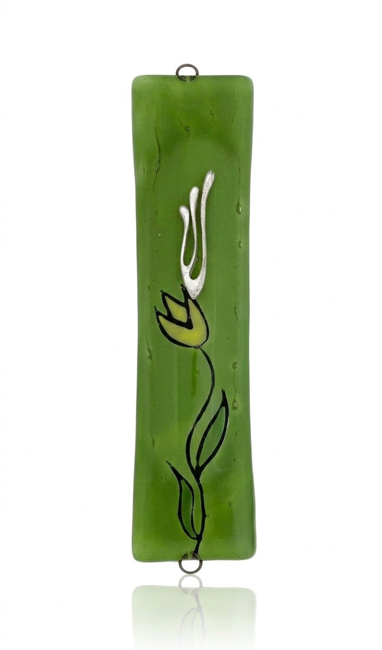Made of glass with intricate floral and Hebrew motifs, green flower mezuzah displayed on a white background with soft reflection.
