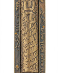 Large brass Mezuzah with Hebrew inscription 'Guardian of the doors of Israel', precise details, engraved text, and textured surface, on a white studio background with light reflection.