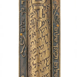Large brass Mezuzah with Hebrew inscription 'Guardian of the doors of Israel', precise details, engraved text, and textured surface, on a white studio background with light reflection.
