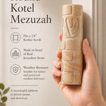 Person holding a Jerusalem stone mezuzah with detailed texture and engraving, showcasing its authenticity in a refined retail environment.