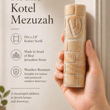 Person holding a Jerusalem stone mezuzah with detailed texture and engraving, showcasing its authenticity in a refined retail environment.