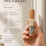 Person holding an authentic Jerusalem stone mezuzah, showcasing its textured layers, natural stone color variation, and meaningful design, in a premium store setting.