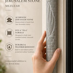 Person holding an extra large Jerusalem stone mezuzah, showcasing its brick-style relief and carved Shin, in a natural setting.