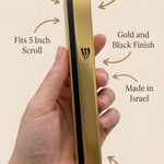 Person holding a gold and black aluminum outdoor mezuzah showing its material and design features.