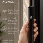 Person holding a sleek black aluminum mezuzah with Shin detail, showcasing its design and scale for e-commerce presentation.