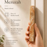 Person holding the exact Jerusalem stone mezuzah at realistic scale, demonstrating size and material for a premium Mezuzah Store display.