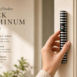 Person holding a black aluminum mezuzah with silver rings and Hebrew Shin, designed for contemporary interiors and dark hardware.